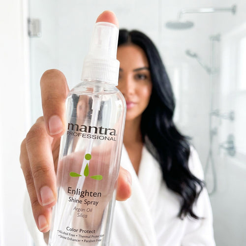 Woman with glossy hair holding a bottle of Mantra Enlighten Shine Spray up to the camera