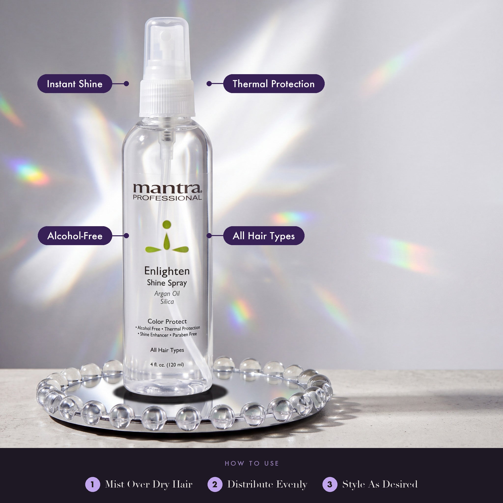 Mantra Enlighten Shine Spray on a chrome disc with glass spheres and prism light: instant shine, thermal protection, alcohol-free, all hair types. How to use: mist over dry hair, distribute evenly, style as desired